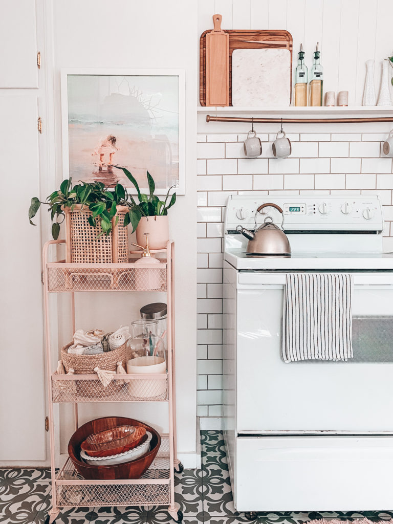 pink kitchen cart with plant and art