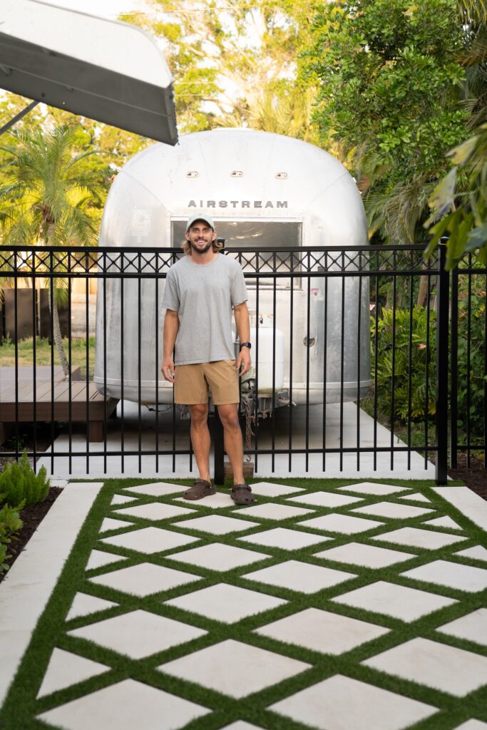 man standing in front of fence and airstream