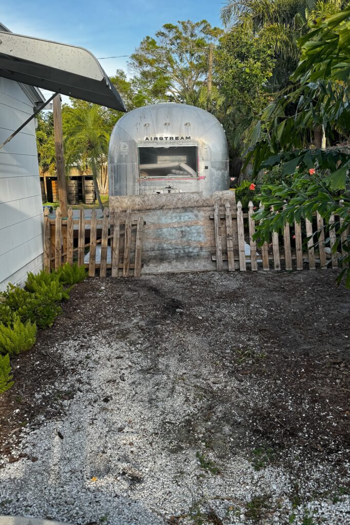 dirt area in front of old fence and airstream