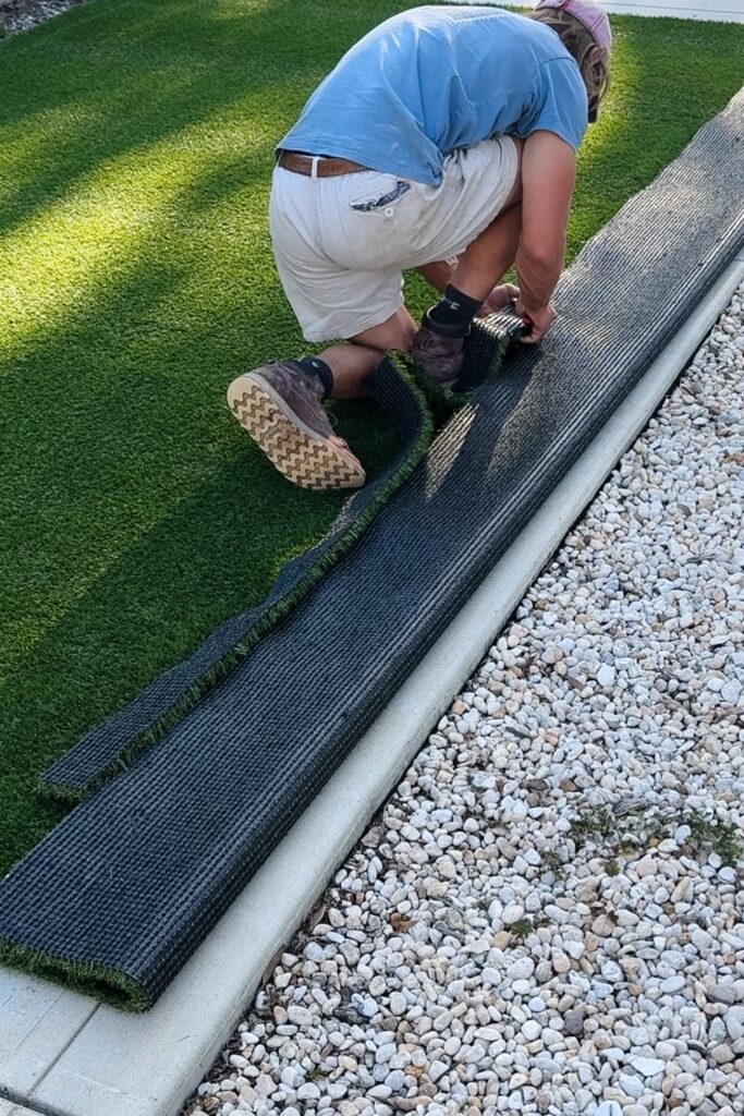 man cutting artificial turf