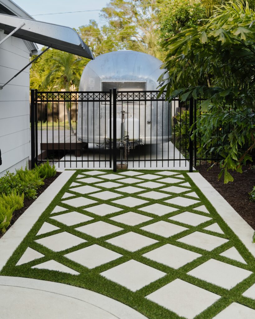 black fence and diamond pavers with artificial turf